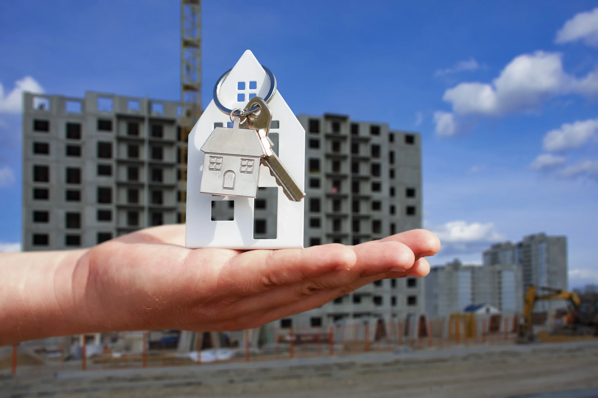 Services et syndic man-holds-keys-house-his-hands-against-background-multi-storey-building-concept-buying-renting-apart